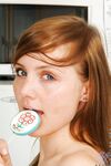 Red Haired Teen Babe Beth Nubiles Slowly Strips While Eating A Lollipop.