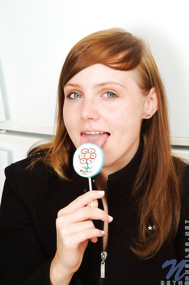 Red Haired Teen Babe Beth Nubiles Slowly Strips While Eating A Lollipop.
