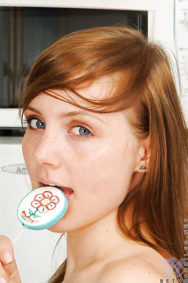 Red Haired Teen Babe Beth Nubiles Slowly Strips While Eating A Lollipop.